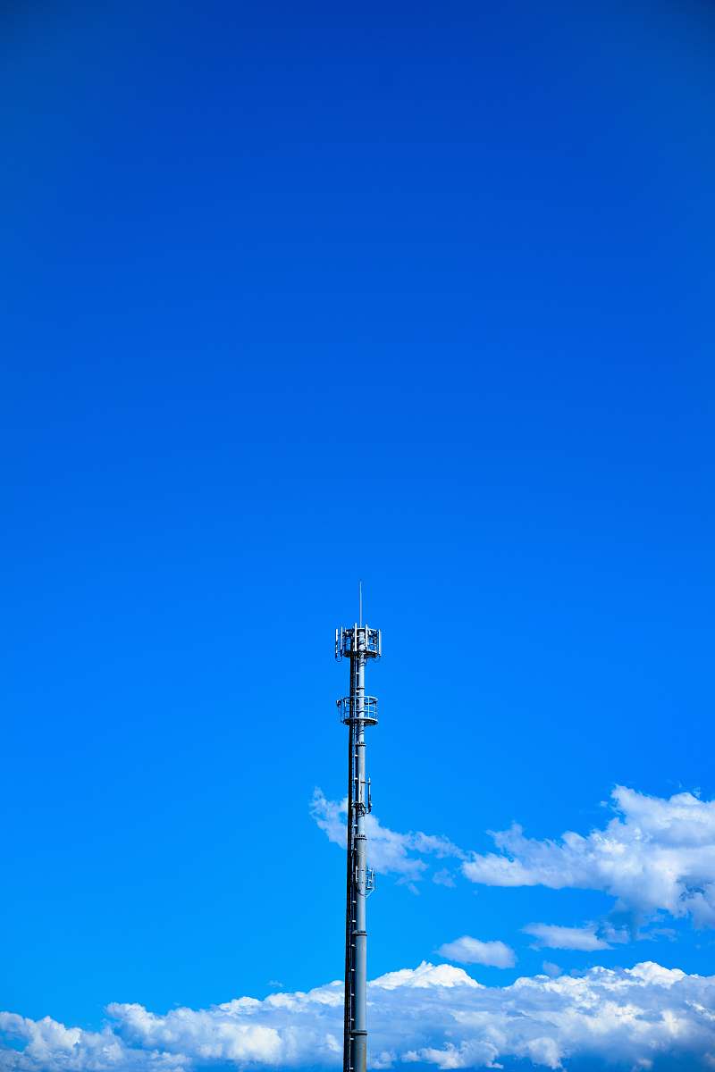 electrical device gray tower under blue cloudy sky antenna